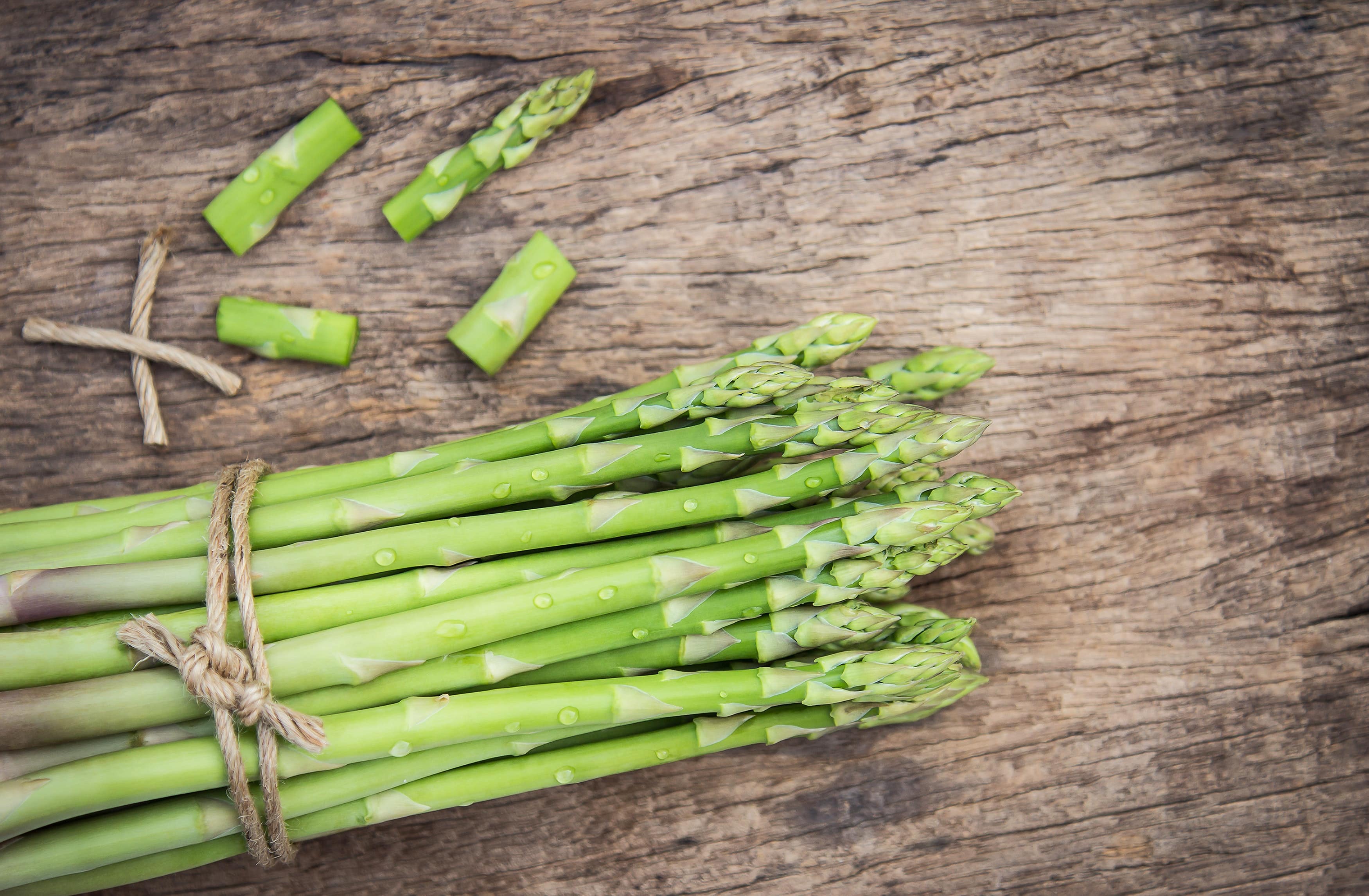 bunch-of-asparagus-tied-with-string-on-a-wooden-surface