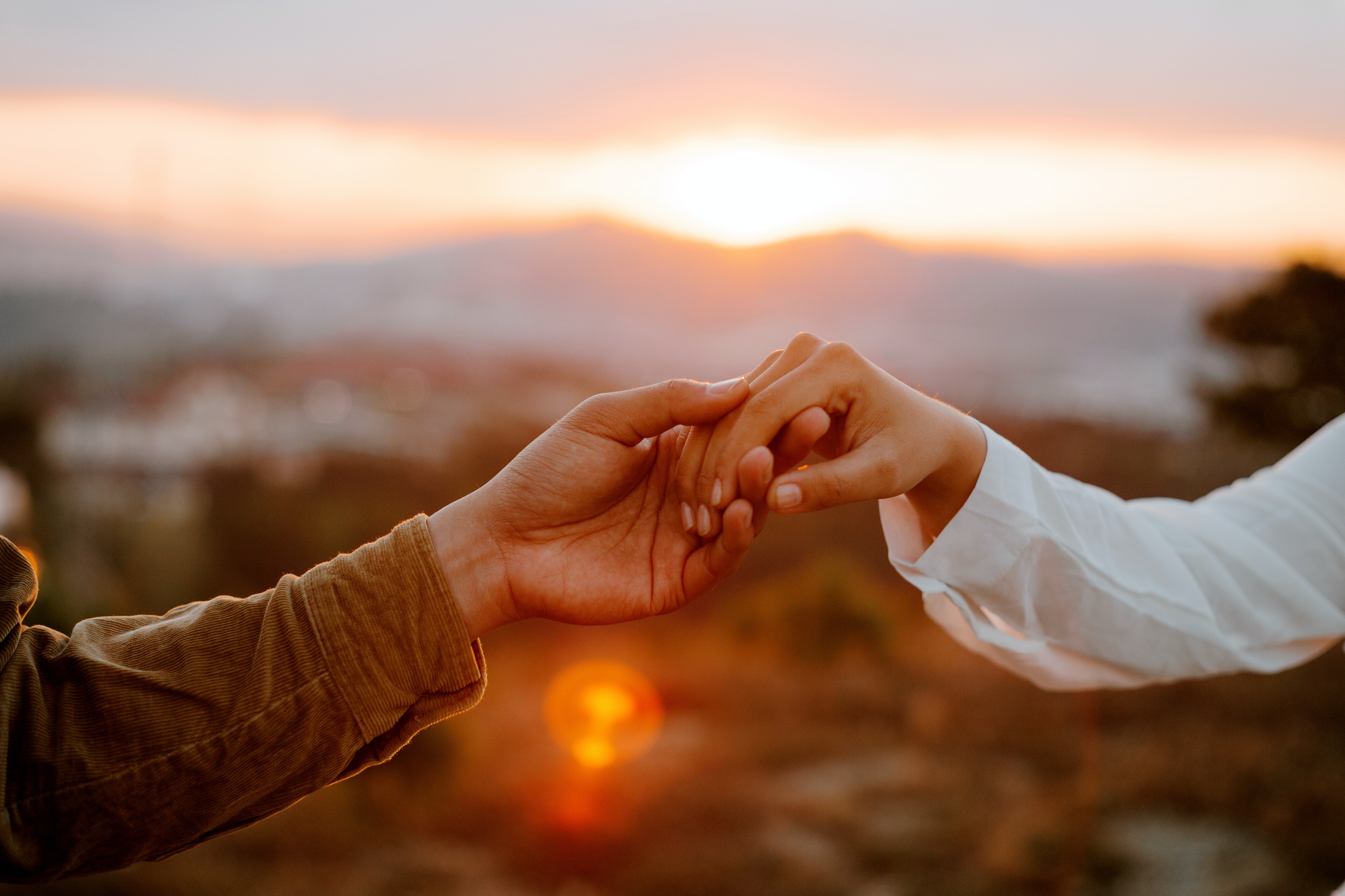 couple-holding-hands-at-sunset