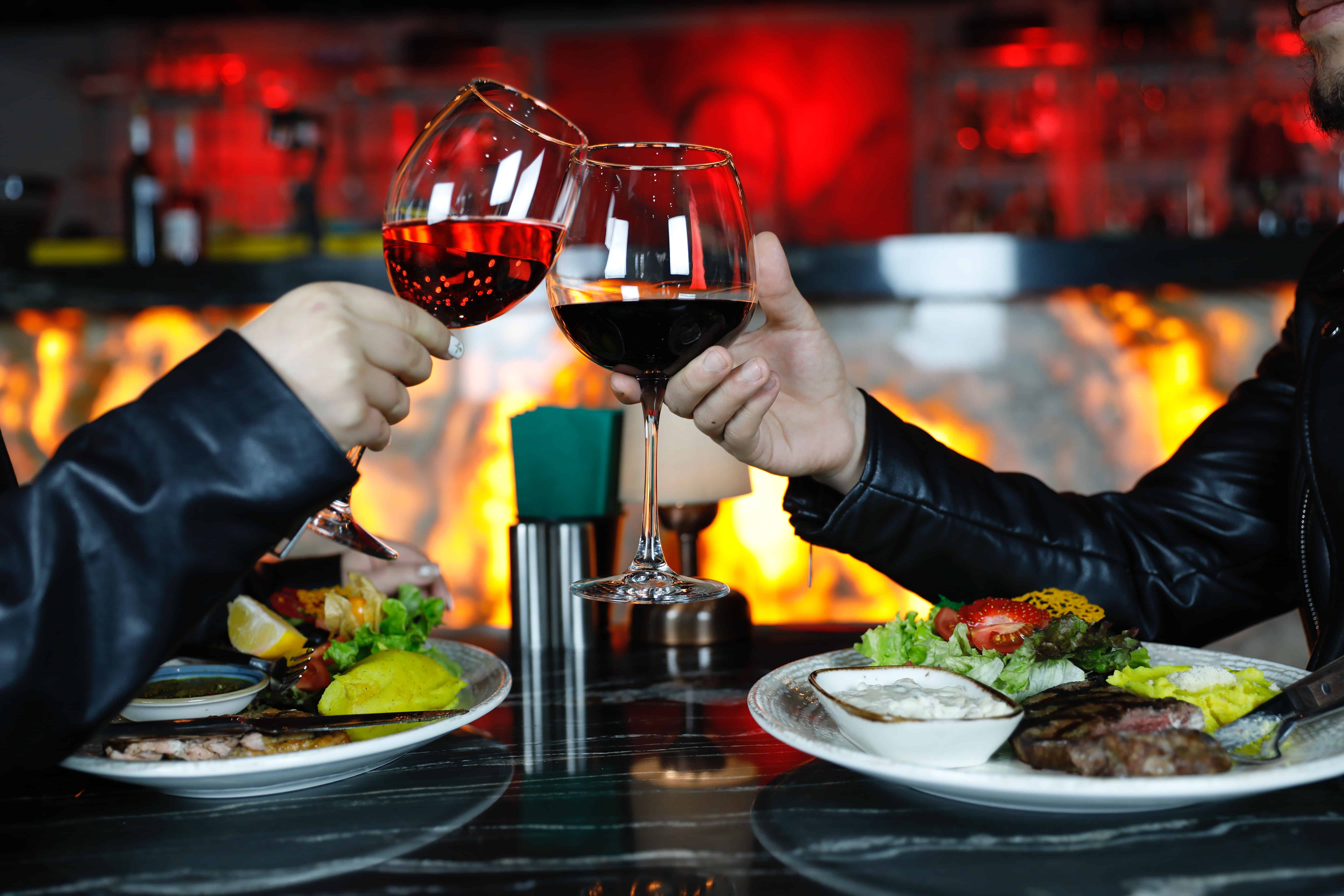 two-people-having-dinner-toasting-with-wine-glasses