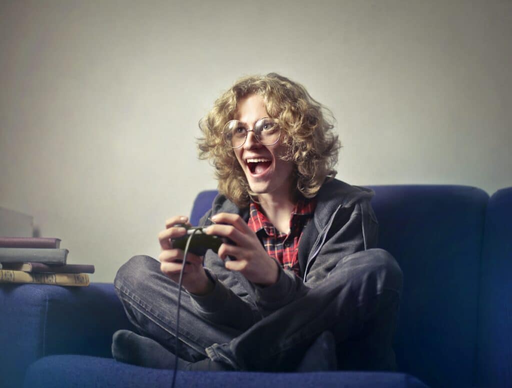 gamer-sitting-on-sofa-smiling-while-holding-console