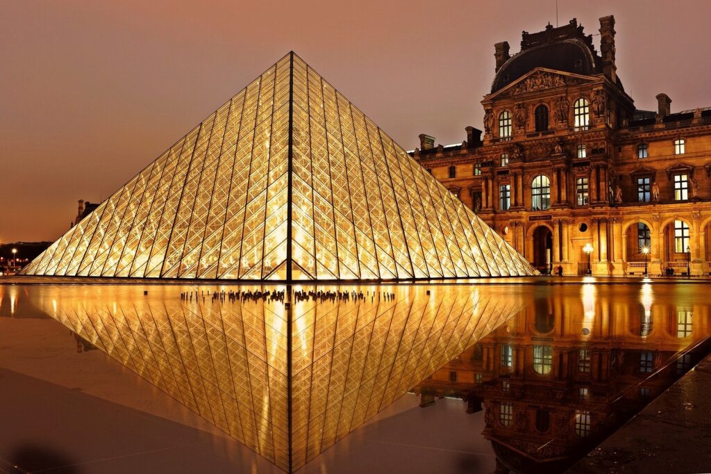 the-Louvre-clear-glass-museum-lit-up-during-sunset-Paris-France