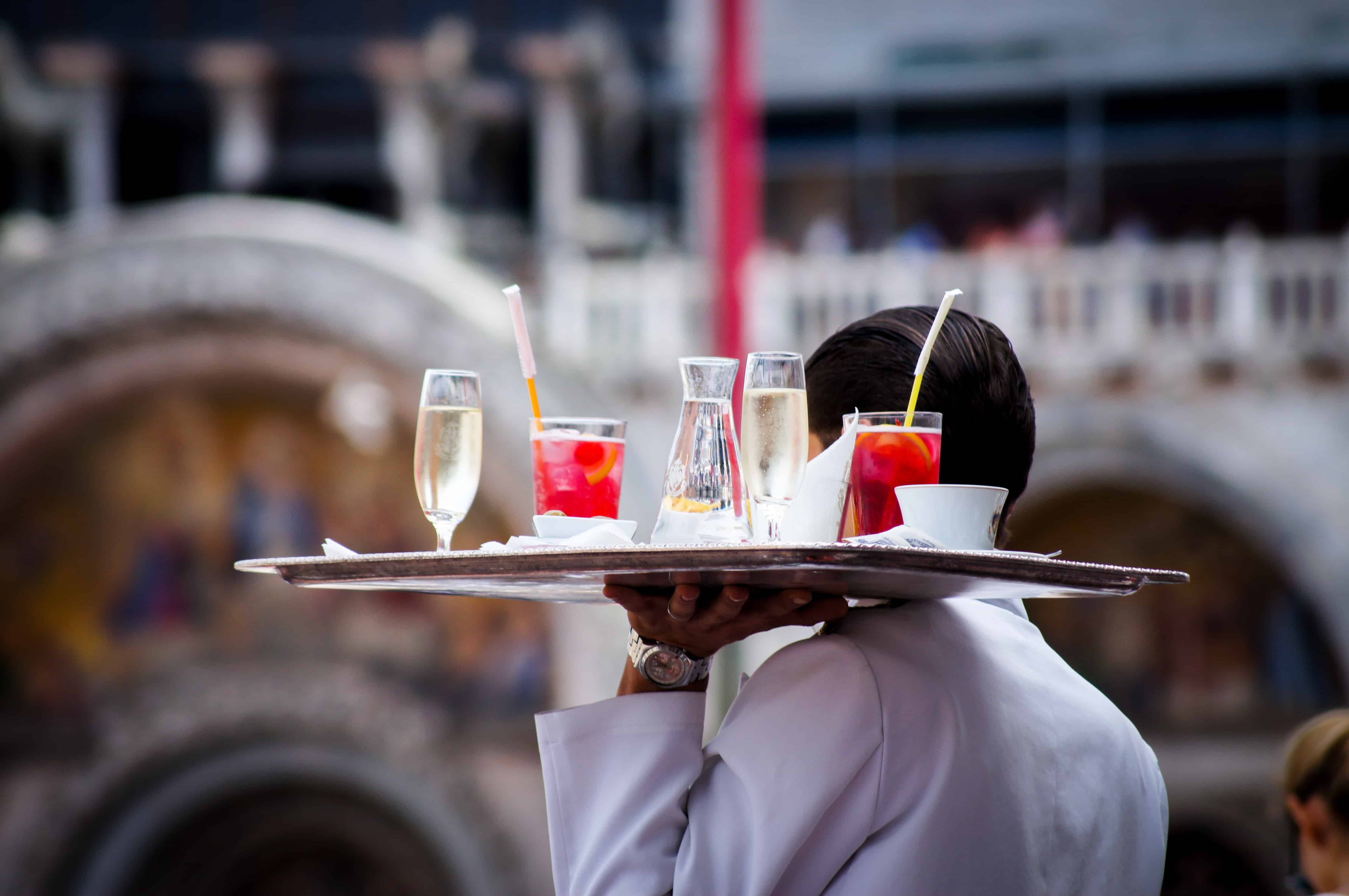 A server carrying a platter of drinks