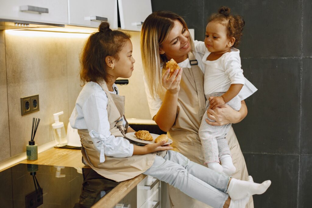 mother-enjoying-croissants-in-the-kitchen-for-breakfast-with-her-two-daughters