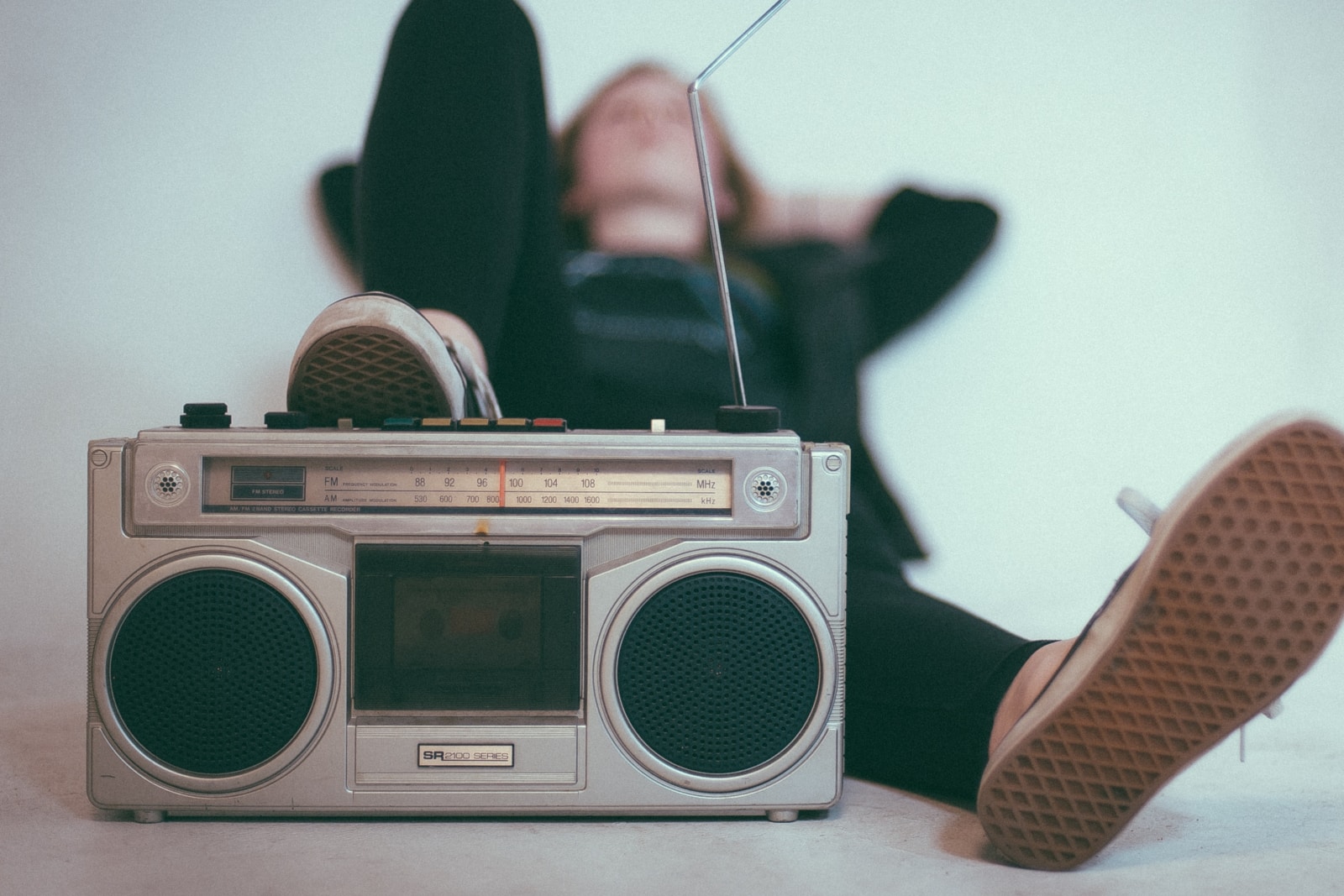 Person lying down with foot up on radio