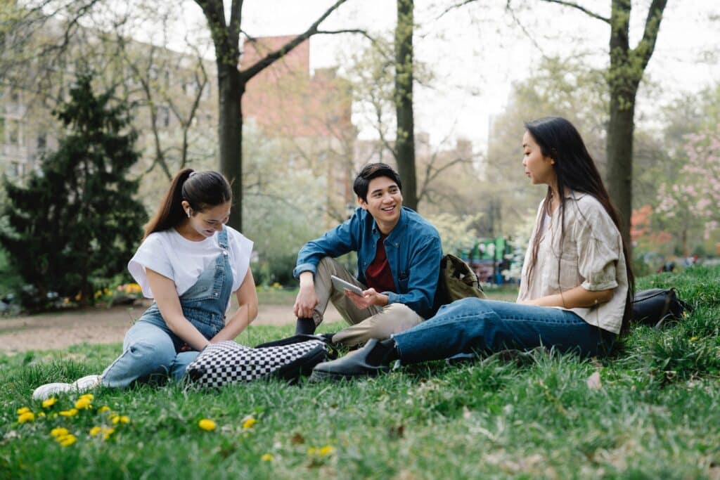 photo-of-a-group-of-friends-sitting-on-the-grass-talking