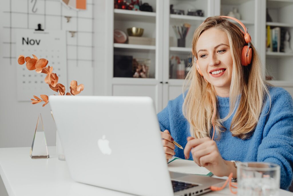 smiling-woman-wearing-headphones-working-on-her-laptop-from-home