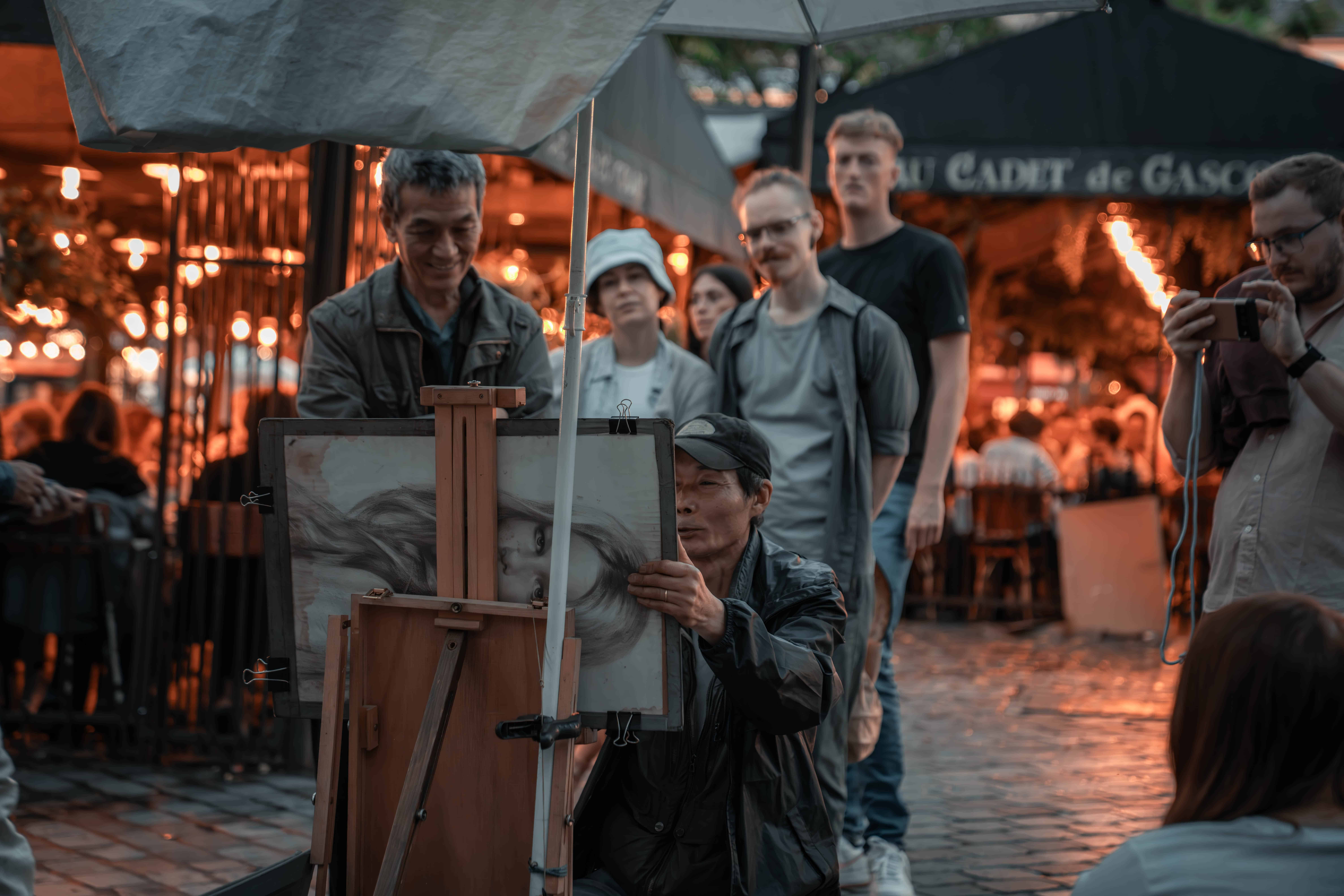People watching an artist paint a painting in Paris