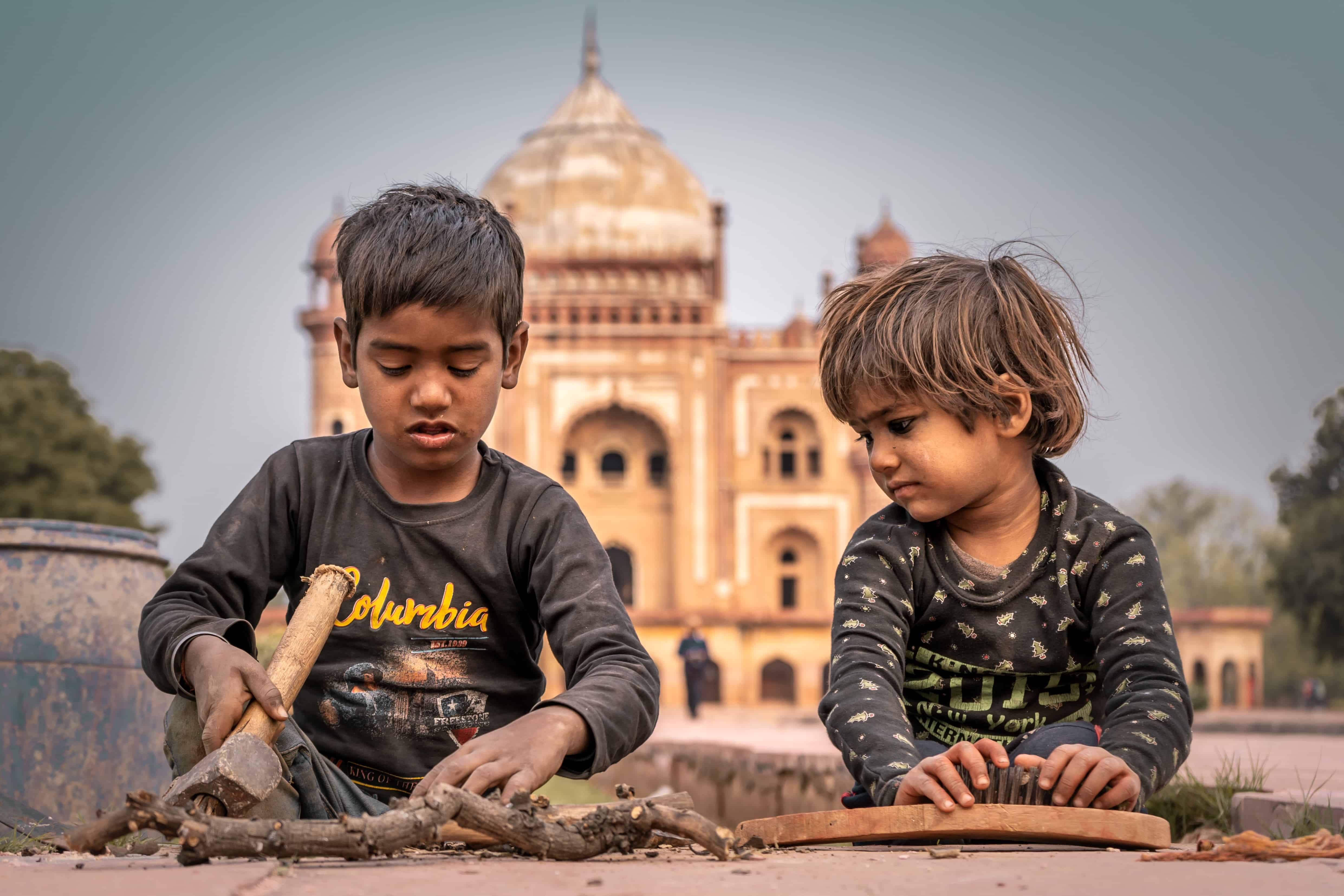 Two boys play in front of a temple