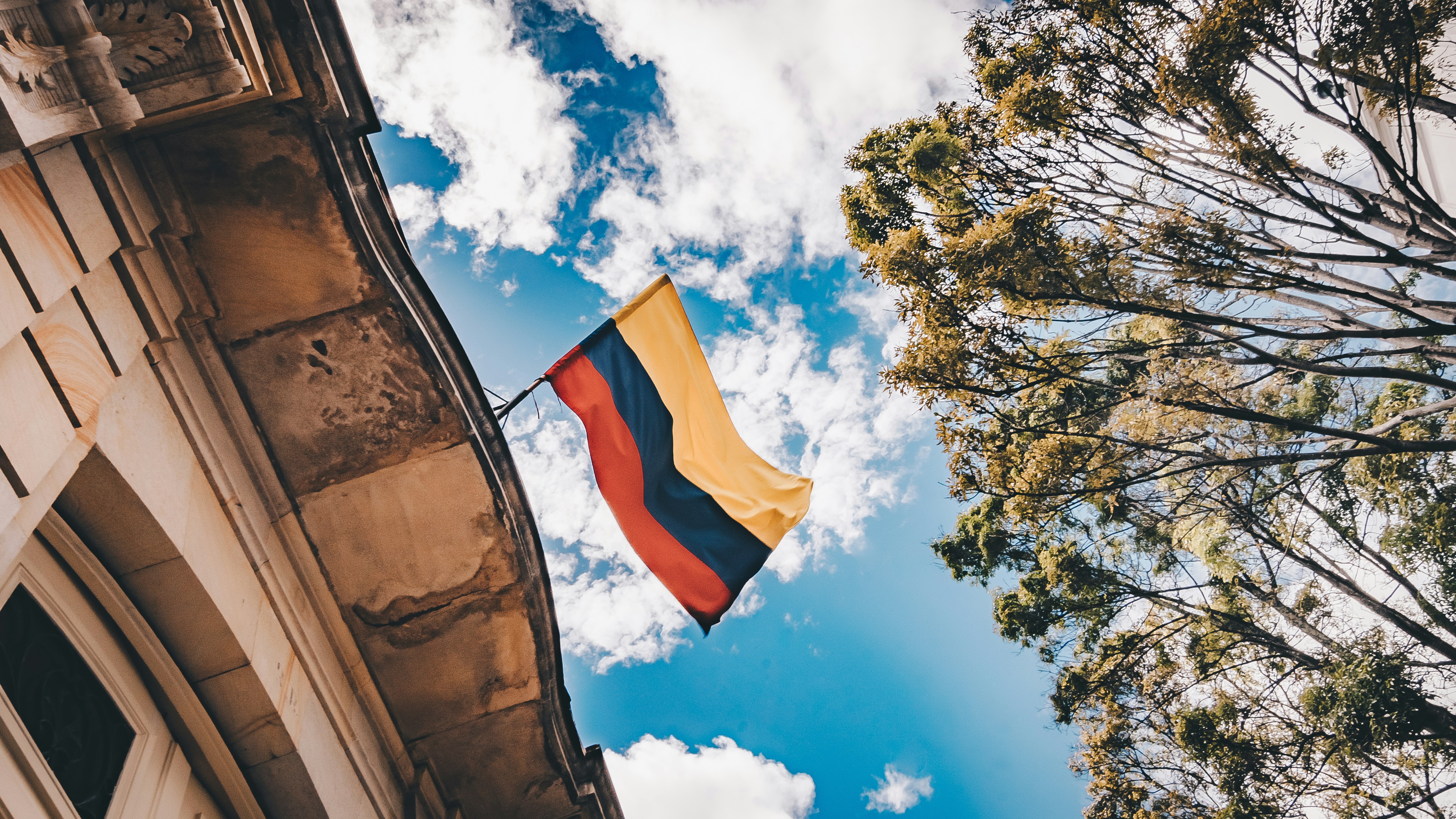 A Colombian flag flies on a historical building