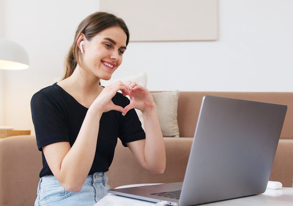 young-woman-on-video-call-making-heart-with-hands
