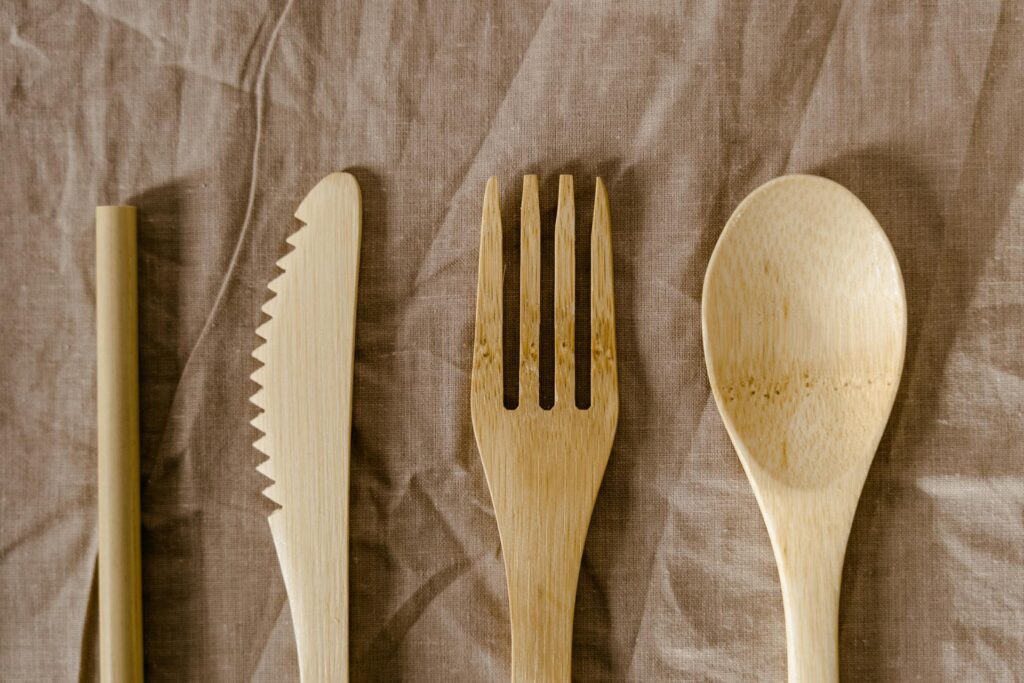 shot-of-wooden-stick-knife-fork-and-spoon-against-brown-cloth