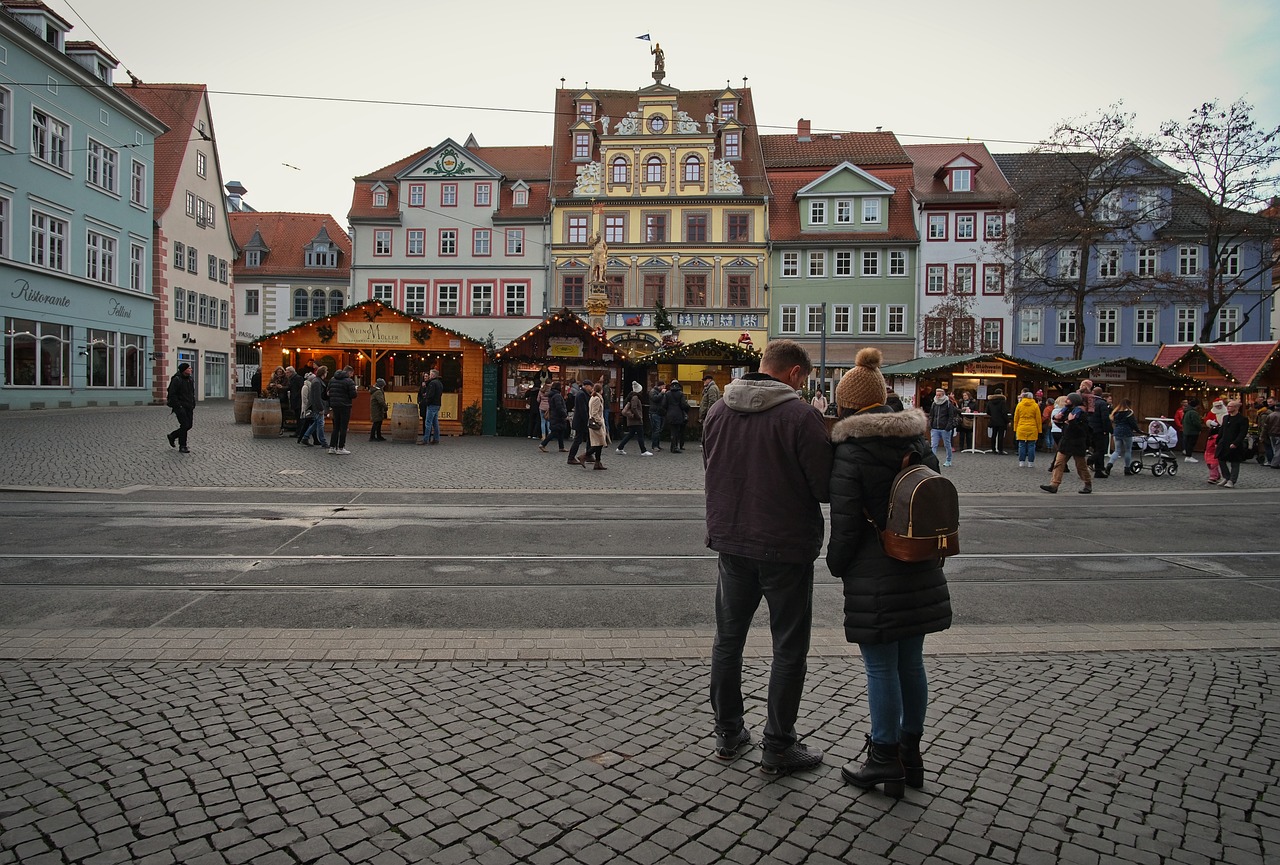 two people standing on the sidewalk in front of colorful buildings