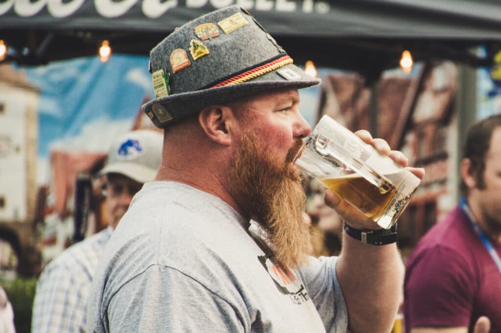 Man drinking a beer and wearing a hat