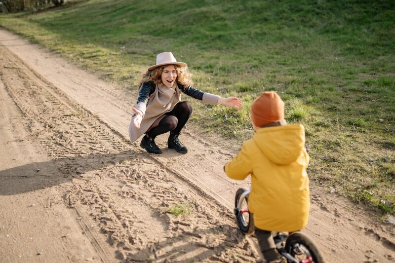 woman-encouraging-child-riding-on-a-bike