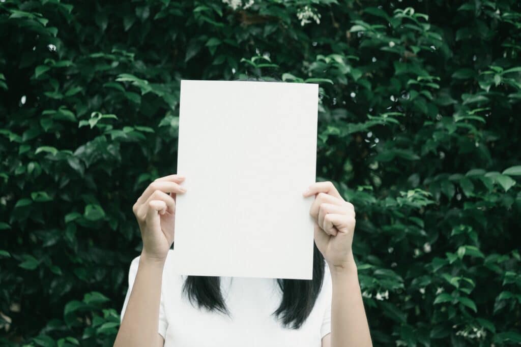 woman-holding-a-piece-of-paper-covering-her-face