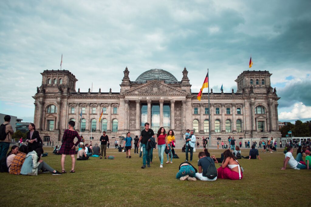 people-sitting-on-lawn-in-front-of-Reichstag-Building