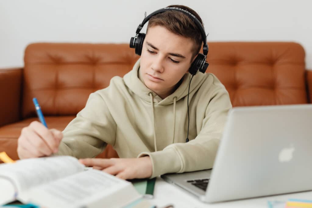 Boy wearing headphones while studying