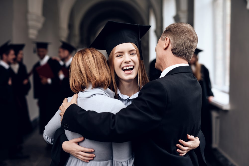 student-hugging-parents-at-graduation