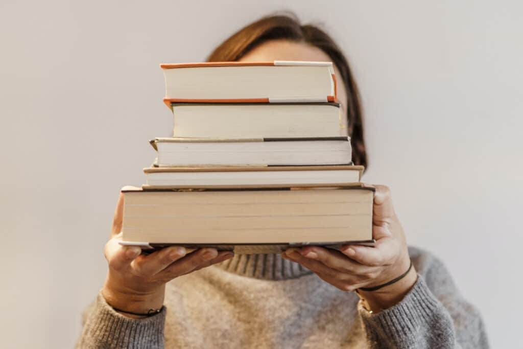 Person holding a stack of books