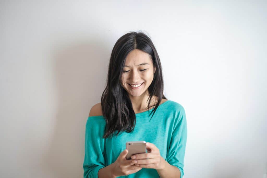 woman-looking-at-phone-and-smiling