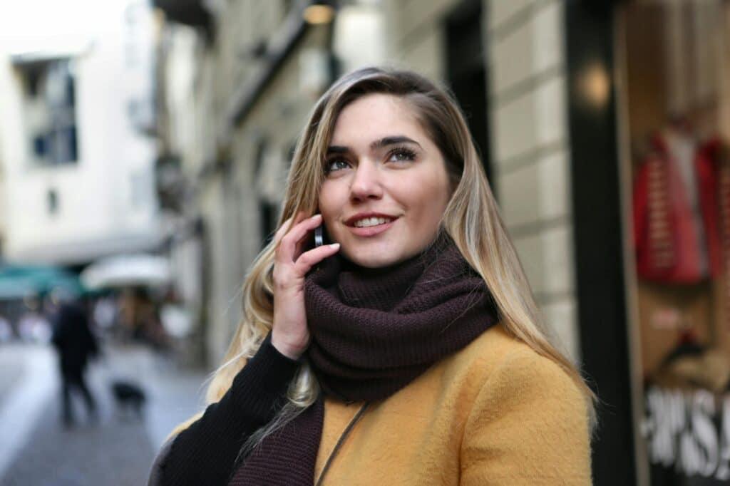 white-woman-in-yellow-coat-talking-on-a-phone
