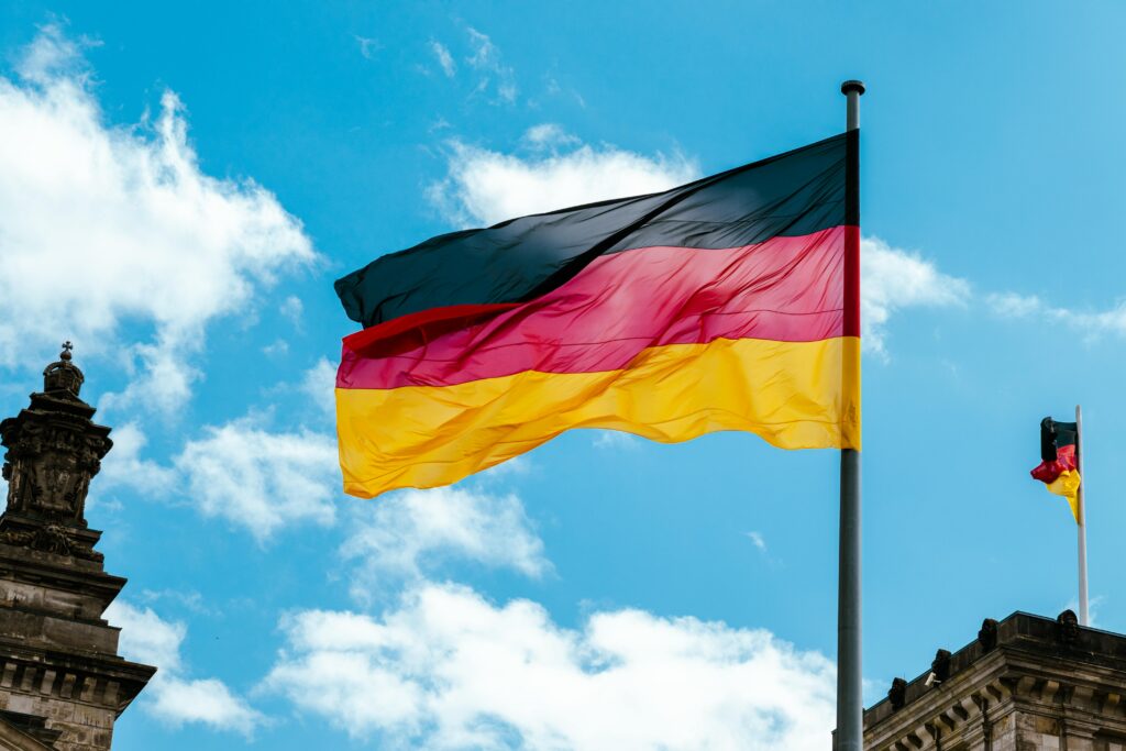 Photo by Luna Groothedde: https://www.pexels.com/photo/the-german-flag-waving-on-a-flagpole-12782140/