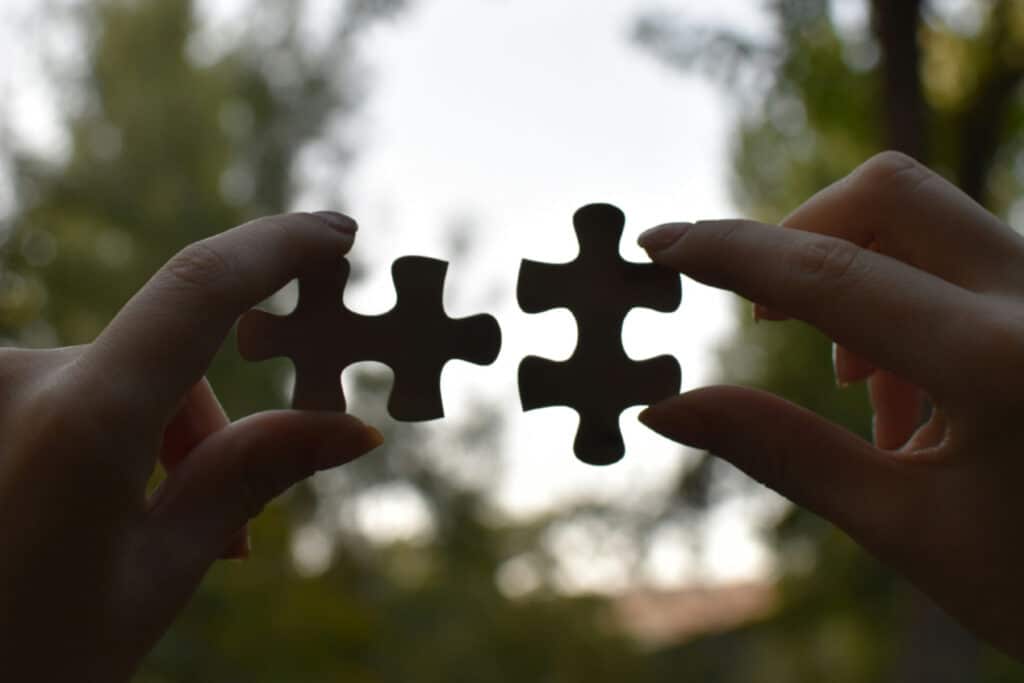 Hands putting puzzle pieces together