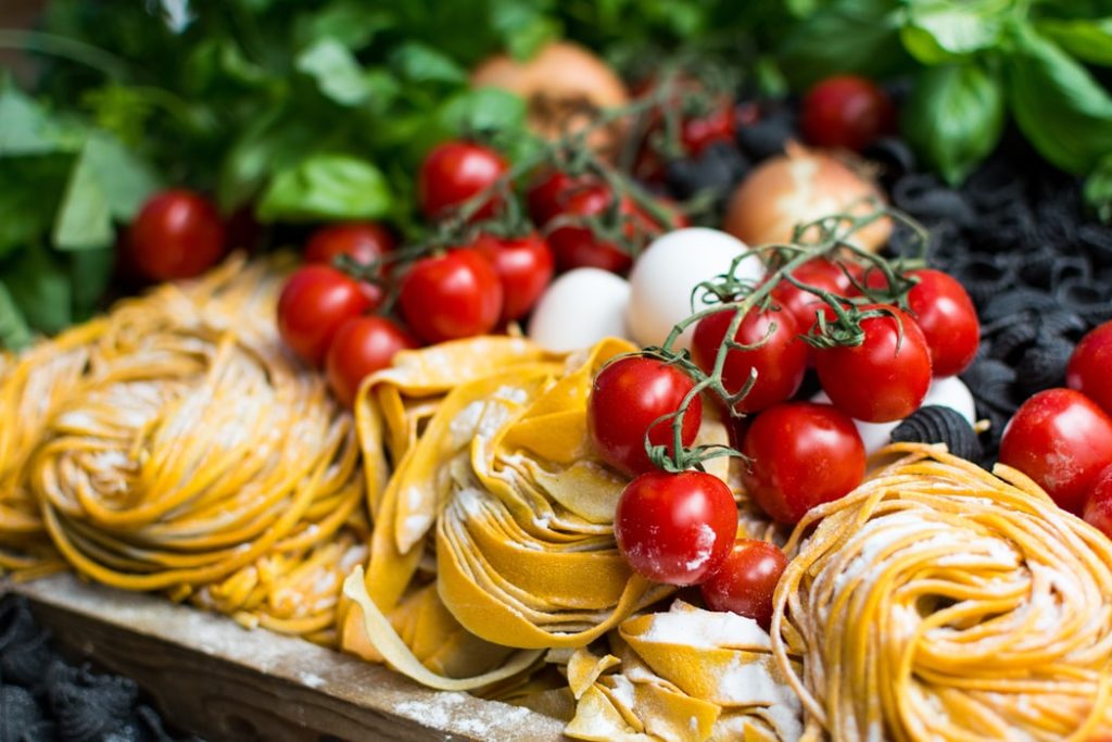 Pasta and tomatoes with other food on a plate