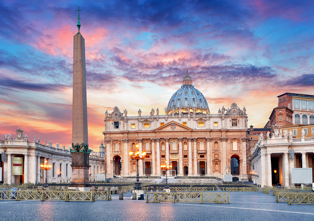 St. Peter's Basilica in the Vatican with atmospheric sunset lighting.