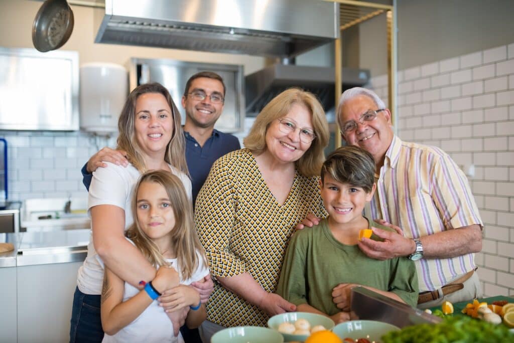 A family including parents, grandparents, and children together in a modern kitchen