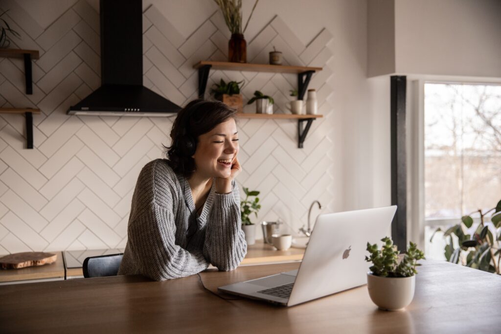 picture-of-a-woman-smiling-talking-on-her-laptop-in-the-kitchen