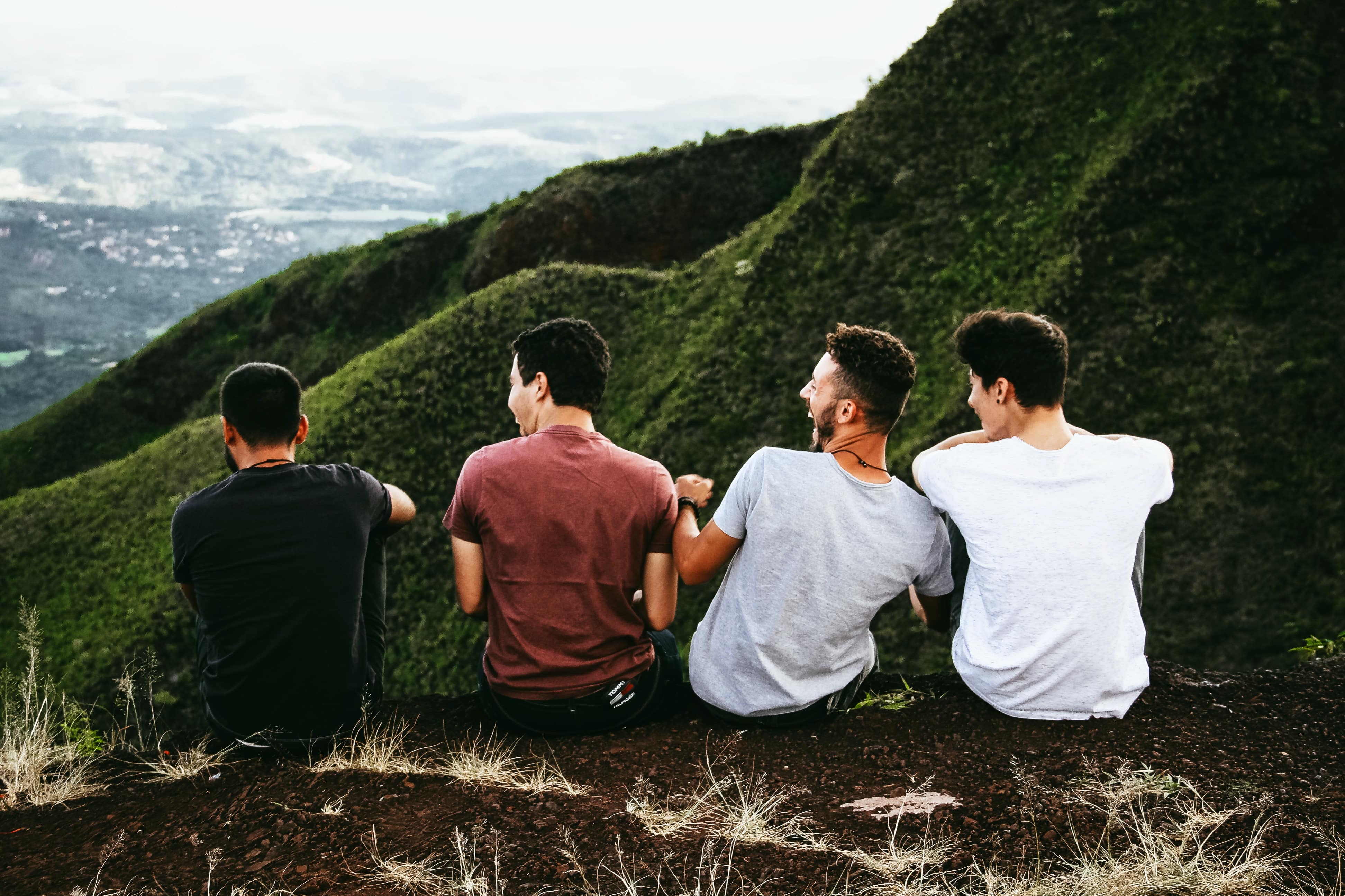 Four friends talk and laugh at a viewpoint