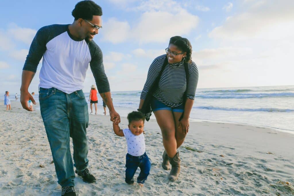 couple-of-african-descent-walk-with-one-young-child-along-beach