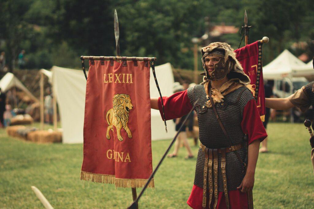 man-in-roman-legionary-costume-holding-up-red-flag-with-lion-insignia