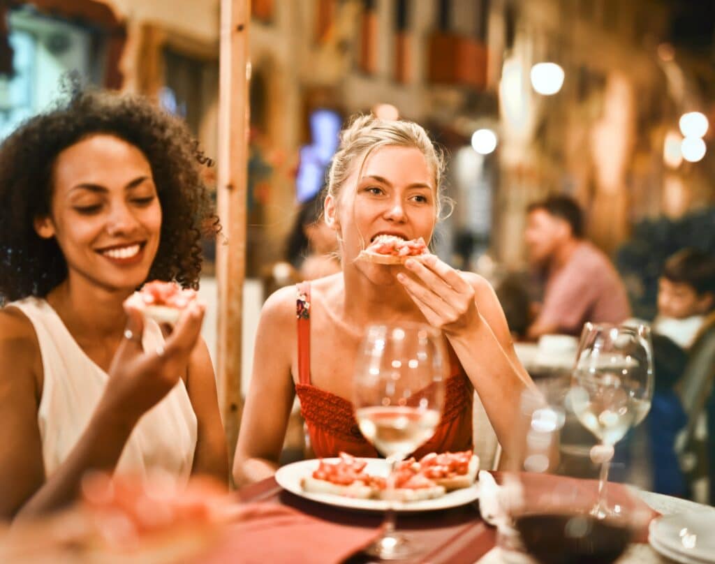 Two women eat Italian food at a restaurant