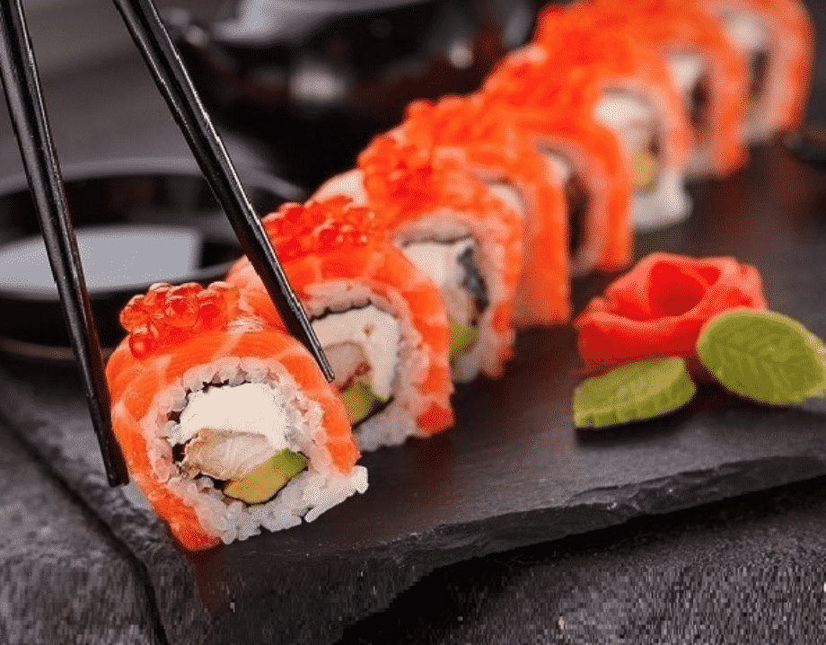 chopsticks picking up sushi on a plate