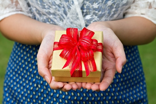 an image of a little box with a red bow in the hands