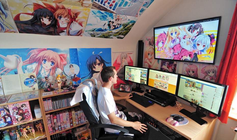 Young man browsing the internet, surrounded by anime and manga collectibles