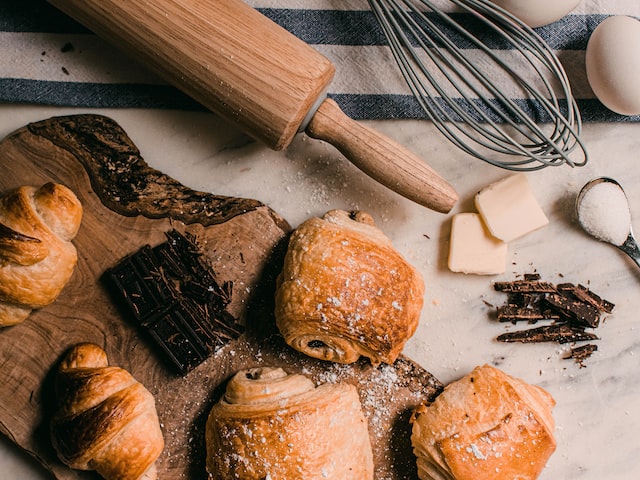 an image of pastries on the board and tools and ingredients to make them