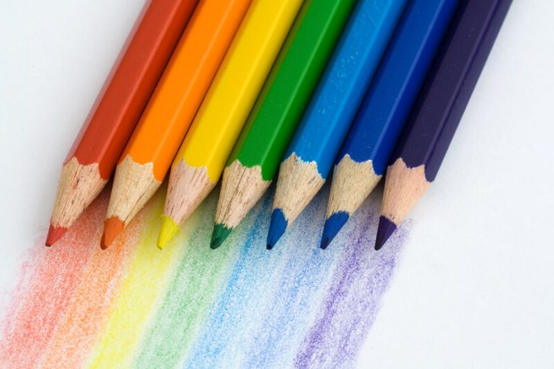 seven color crayons against white background