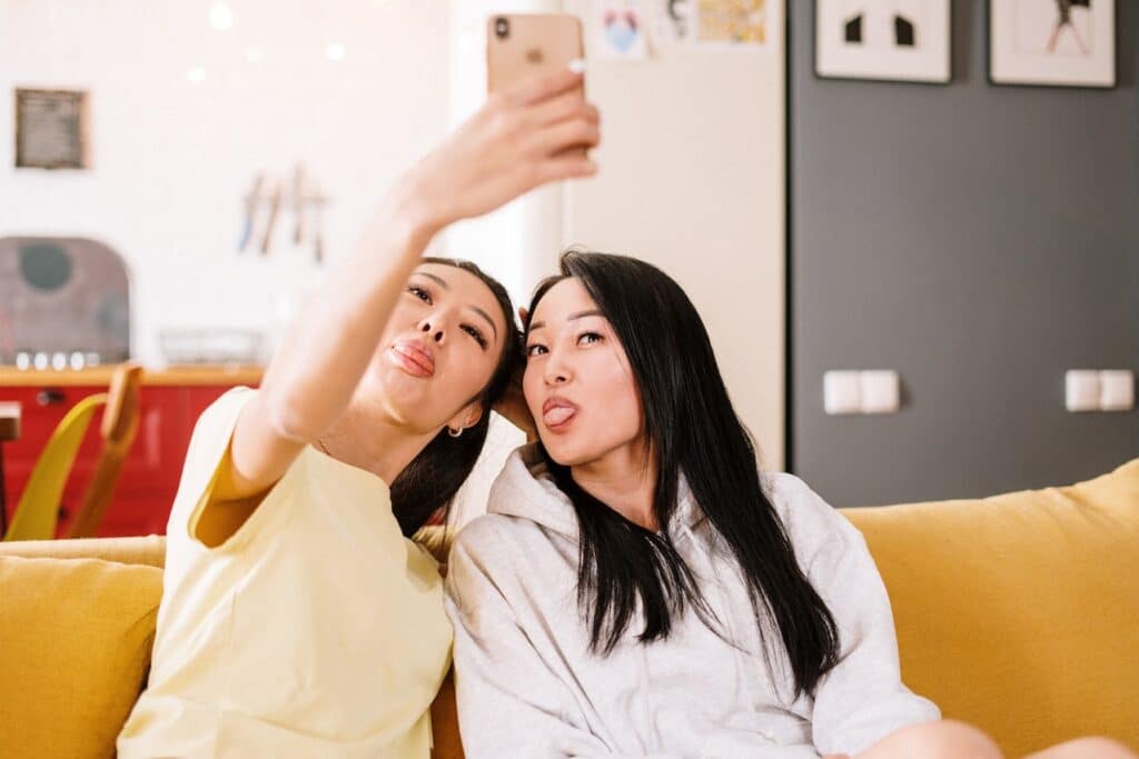two friends on a couch taking a selfie