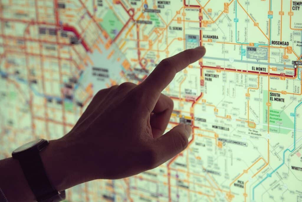 A hand pointing to a station on a subway map