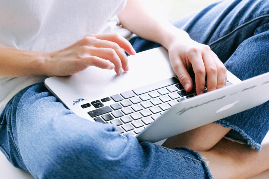 Person in blue jeans using a laptop