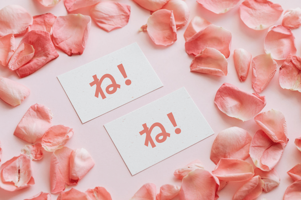two-sheets-of-paper-containing-the-japanese-particle-ne-among-pink-flower-petals