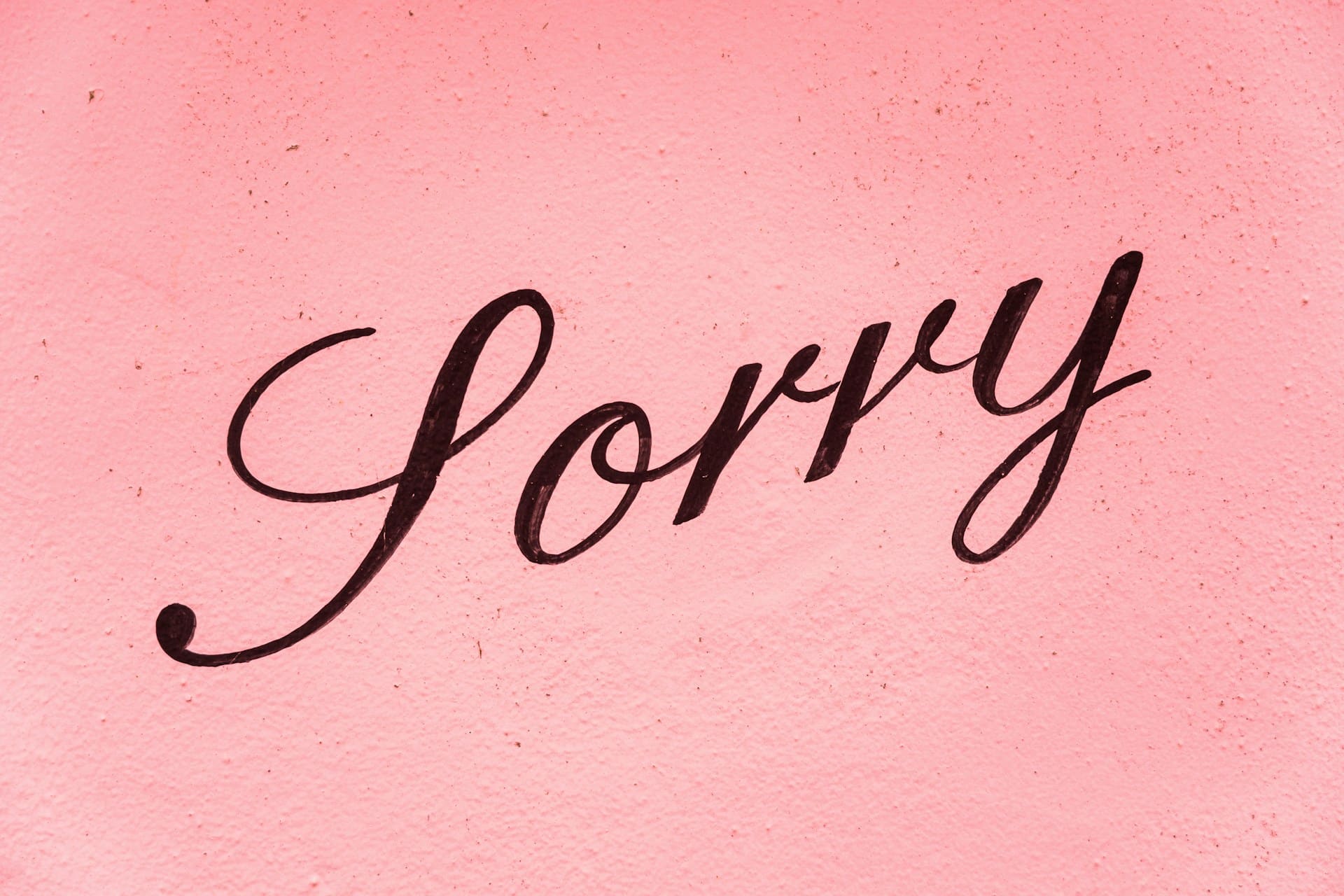 the-word-sorry-in-cursive-writing-against-pink-background