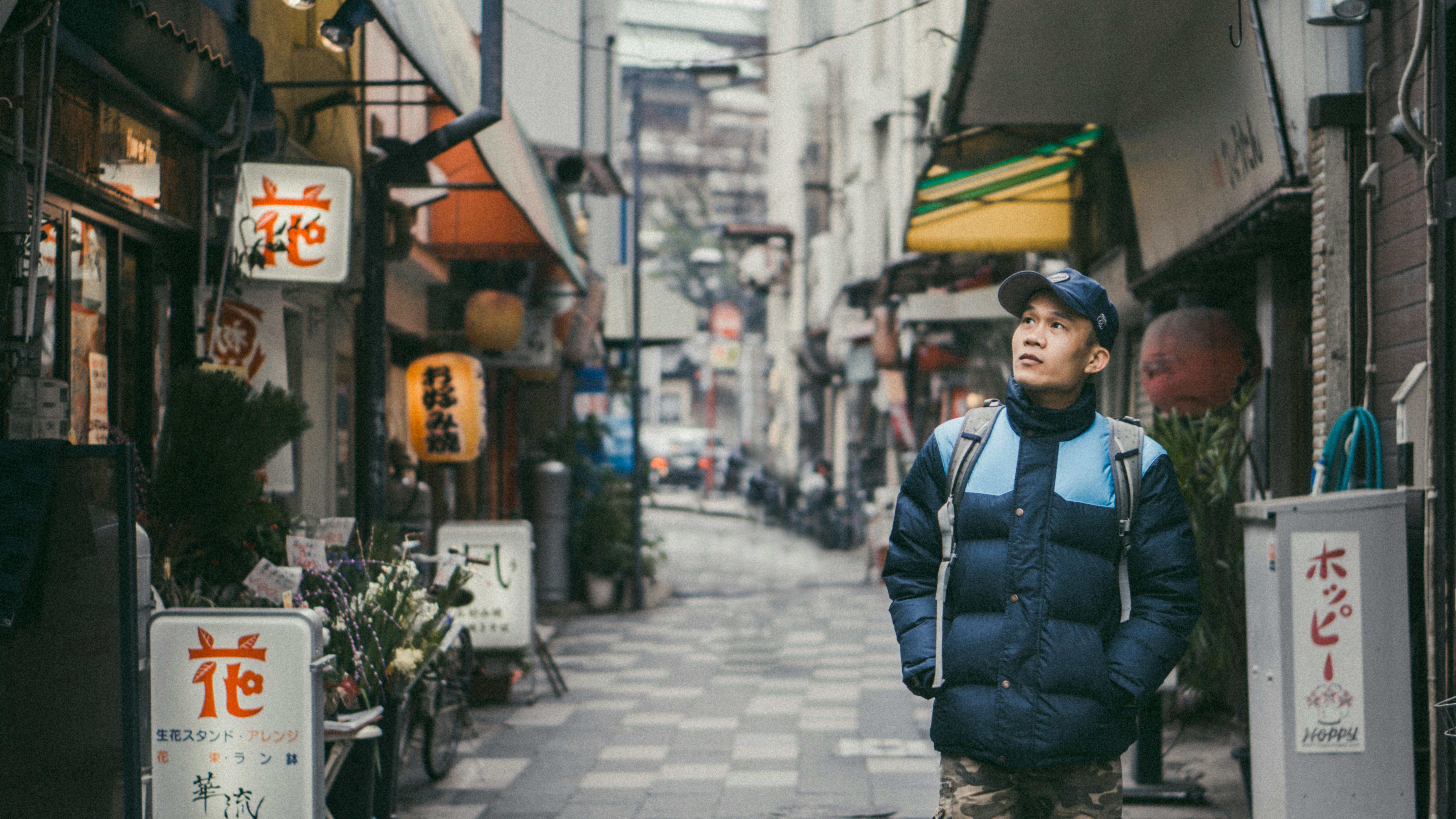 A man walks down a narrow Japanese street