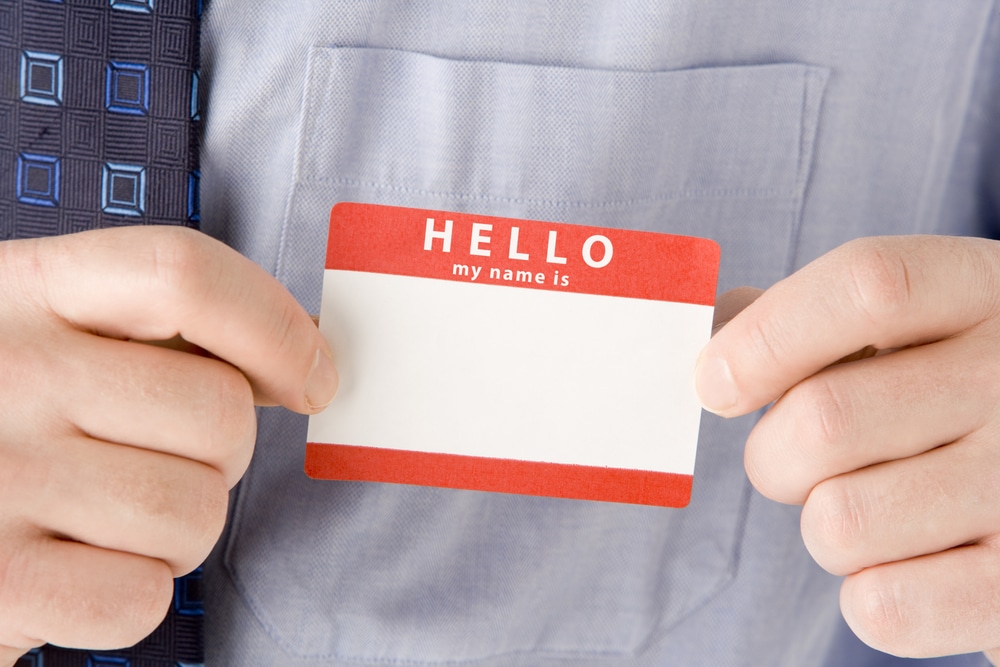 Close-up of businessman holding a blank name tag.