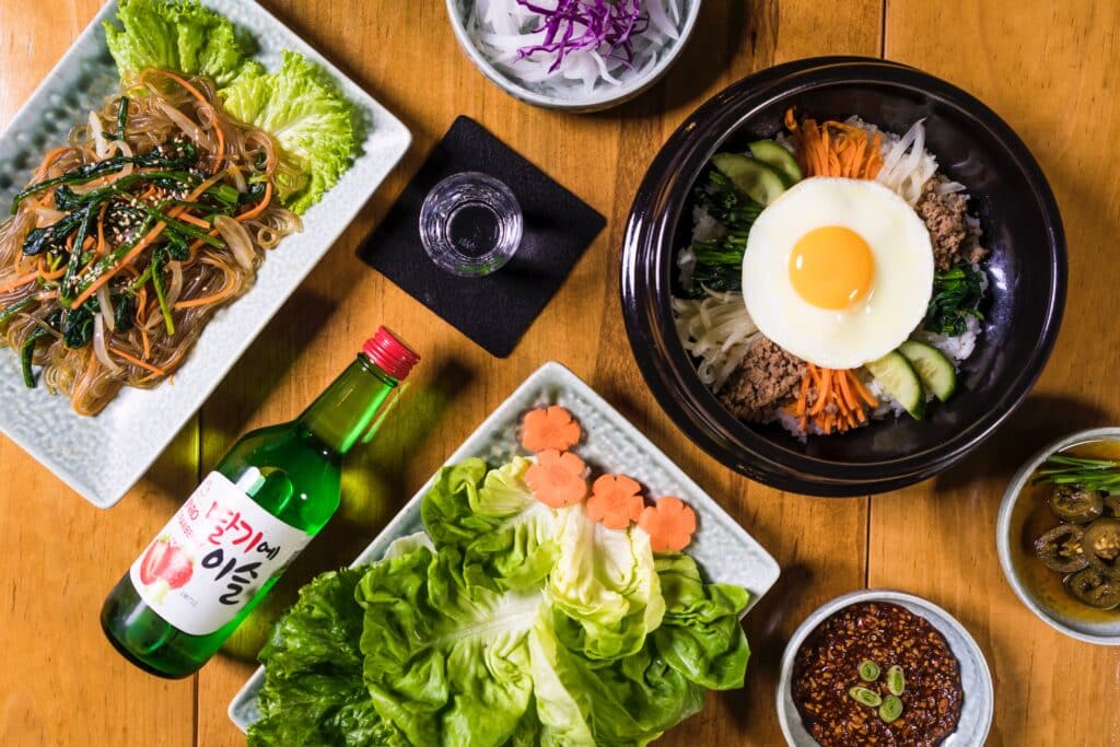 Photo by Becerra Govea Photo: https://www.pexels.com/photo/top-view-of-soju-and-an-assortment-of-korean-food-5773971/