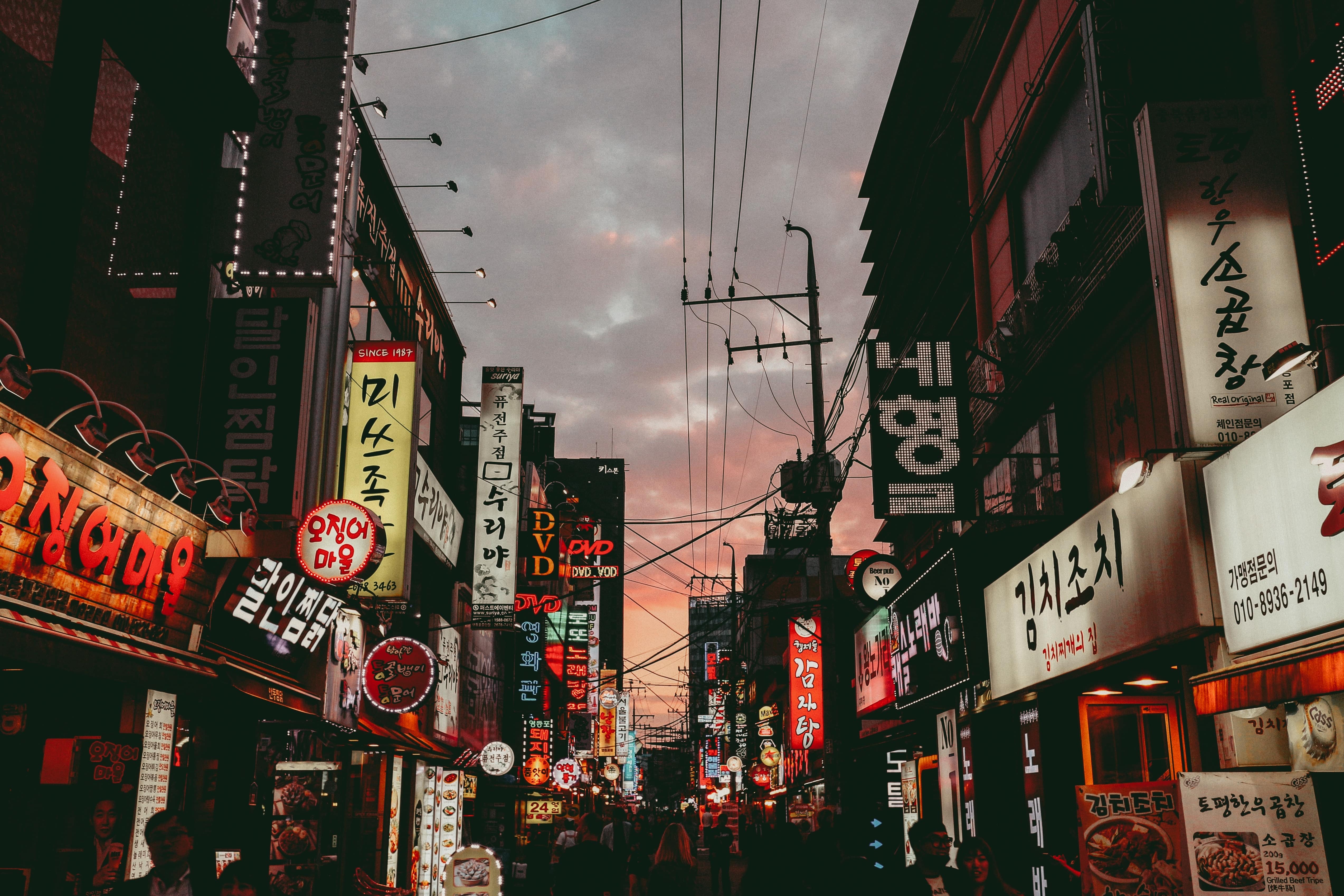An urban Korean street lined with signs at sunset