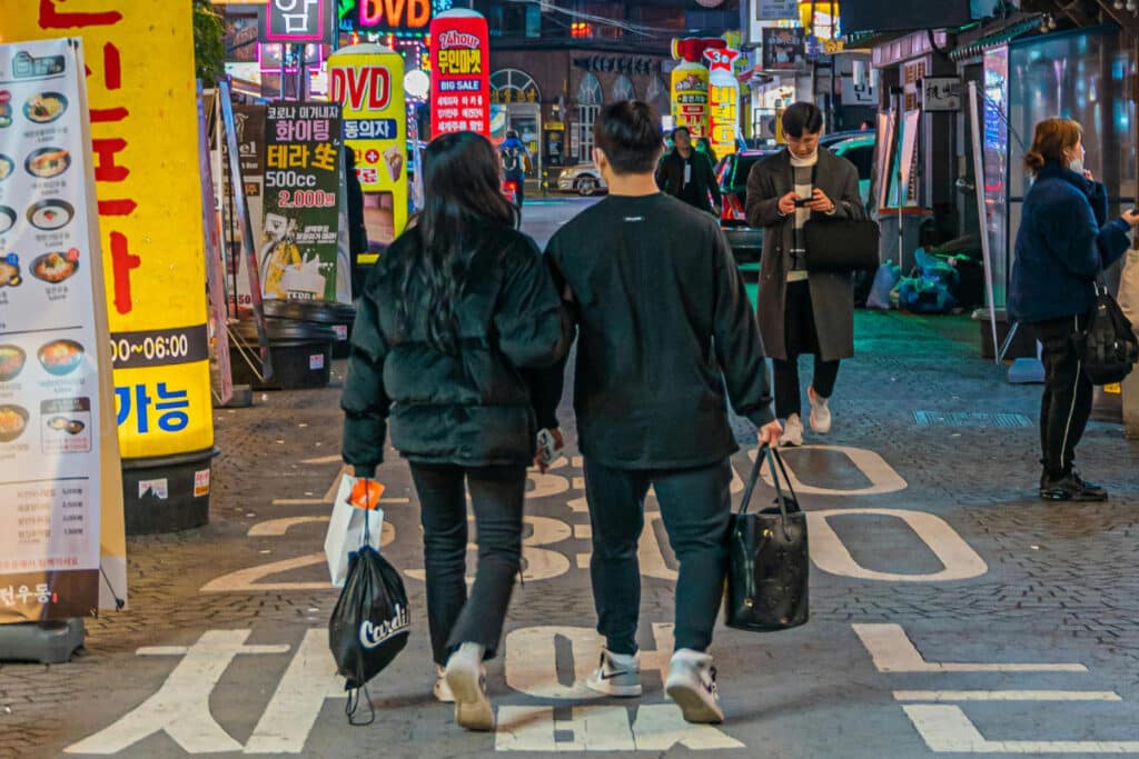 Man and woman walking down a street in Korea